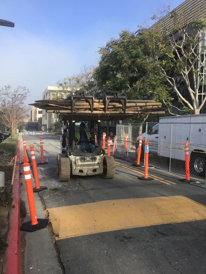 bobcat lifting wooden beams at gmp warehouse irvine