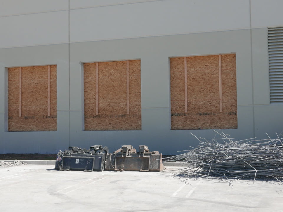 three concrete cutting wall openings boarded up with plywood at ups facility in riverside, ca