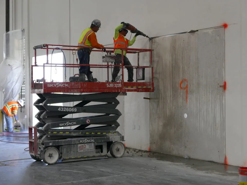 technicians on lift saw cutting a wall opening at ups facility in riverside, ca