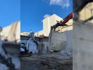 excavator and bobcat performing building demolition at northrop grumman