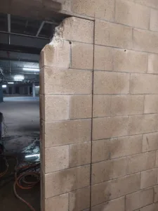 Cinder block wall opening with vertical saw cut for a wall sawing operation